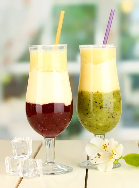 Läcker frukt smoothies på träbord på fönsterbakgrund — Stockfoto