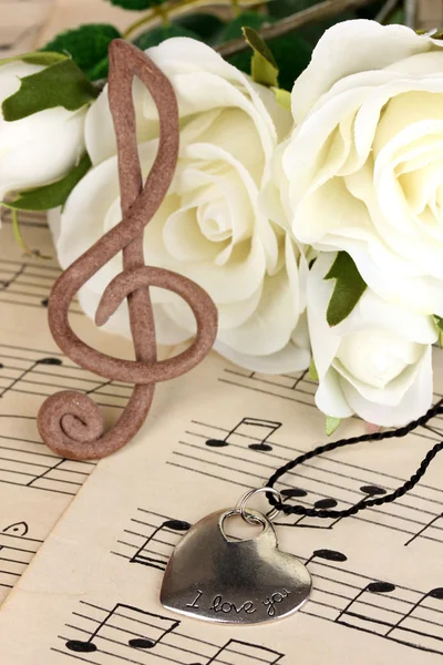 Treble clef, hanger en rozen op muzikale achtergrond — Stockfoto