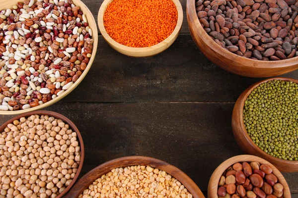 Different kinds of beans in bowls on table close-up — Stock Photo, Image