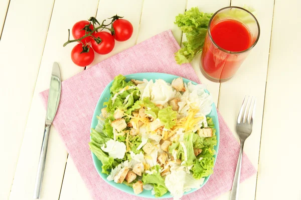 Caesar-Salat auf blauem Teller, auf farbigem Holzhintergrund — Stockfoto