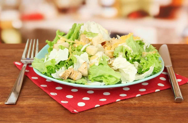 Ensalada César sobre plato azul, sobre fondo brillante — Foto de Stock