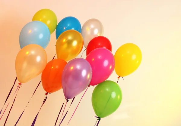 Many bright balloons on orange background — Stock Photo, Image