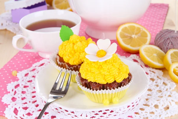 Beautiful lemon cupcakes and flavored tea on dining table close-up — Stock Photo, Image