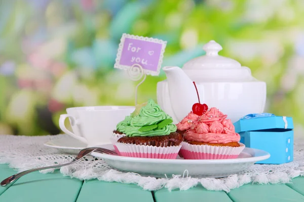 Hermosos cupcakes en mesa de comedor sobre fondo natural — Foto de Stock