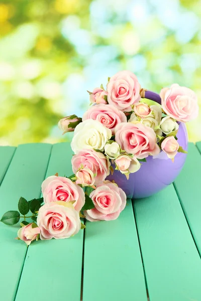 Hrnec s květinami na dřevěný stůl na pozadí přírody — Stock fotografie