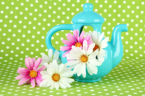Pote com flores em um fundo de tecido verde — Fotografia de Stock