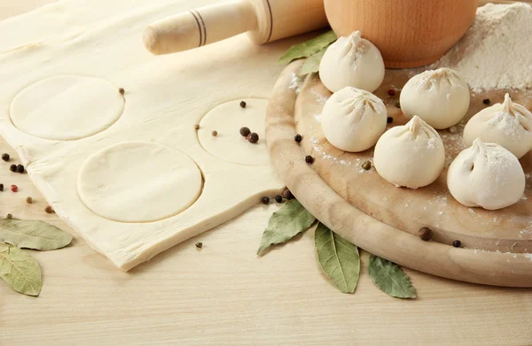 Raw dumplings and dough, on wooden table — Stock Photo, Image