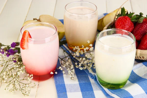Deliciosos yogures con frutas en vasos sobre mesa de madera —  Fotos de Stock