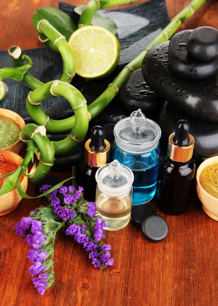 Spas composition with oils and spa stones on wooden table close-up — Stock Photo, Image