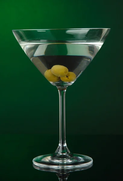 Martini glass with olives on dark green background — Stock Photo, Image