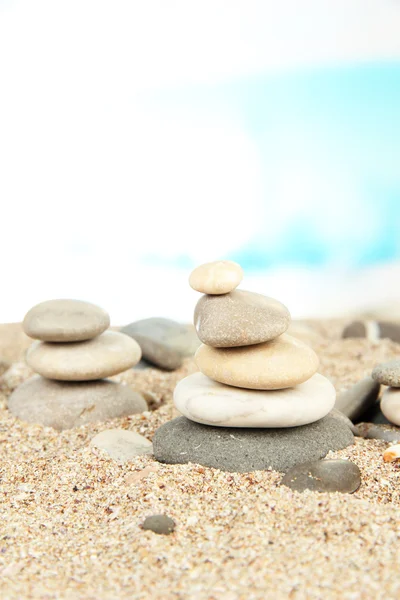 Tower of sea stones on sand on bright background — Stock Photo, Image