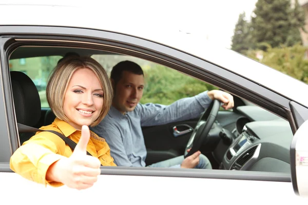 Porträtt av unga vackra paret sitter i bilen — Stockfoto