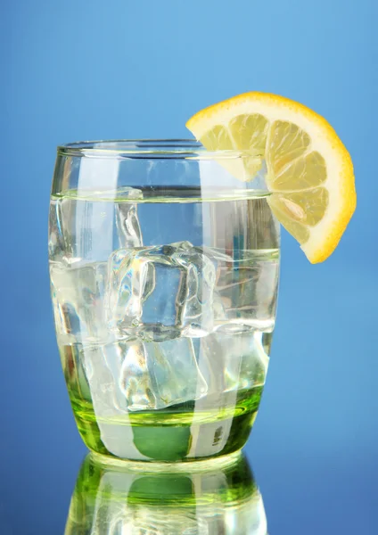 Glass of water and ice on blue background — Stock Photo, Image