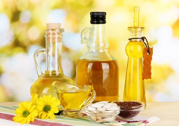 Useful linseed oil and pumpkin seed oil on wooden table on natural background — Stock Photo, Image