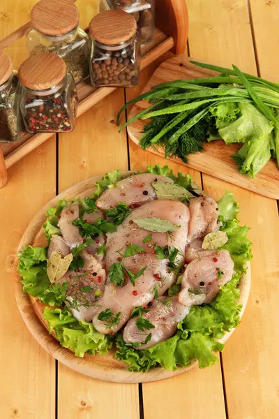 Kycklingkött på träplatta, örter och kryddor på träbord — Stockfoto