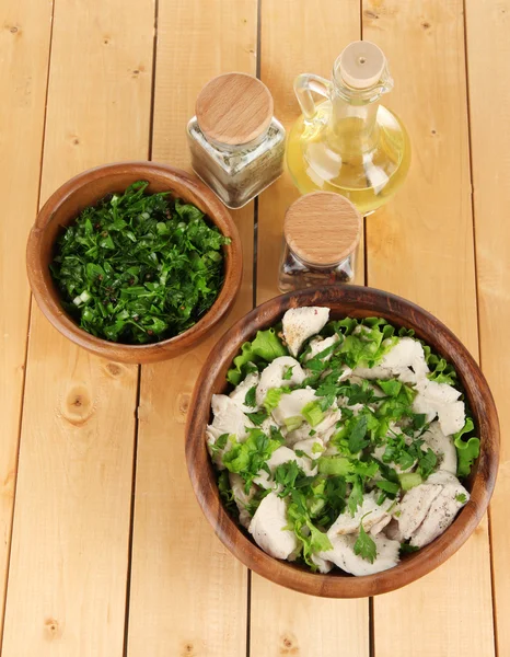 Boiled meat on wooden bowl and herbs on wooden table — Stock Photo, Image