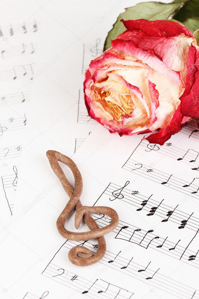 Treble clef and rose on musical background
