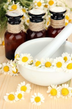 esans ve harç ahşap masa üzerinde papatya çiçeği.