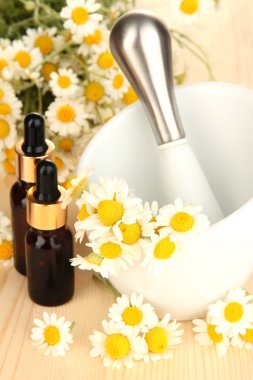 esans ve harç ahşap masa üzerinde papatya çiçeği.