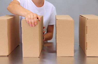 gri arka plan üzerinde Konveyör bant kutuları ile çalışan işçi