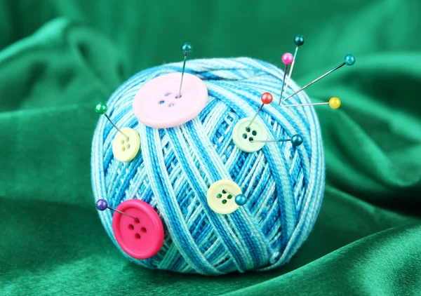 Färgglada knappar och ull bollen, på färg tyg bakgrund — Stockfoto