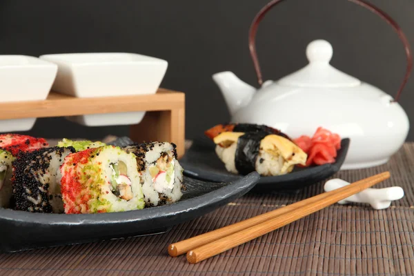 Gustoso sushi Maki - Rotolo su foglia verde sul tavolo su sfondo grigio — Foto Stock