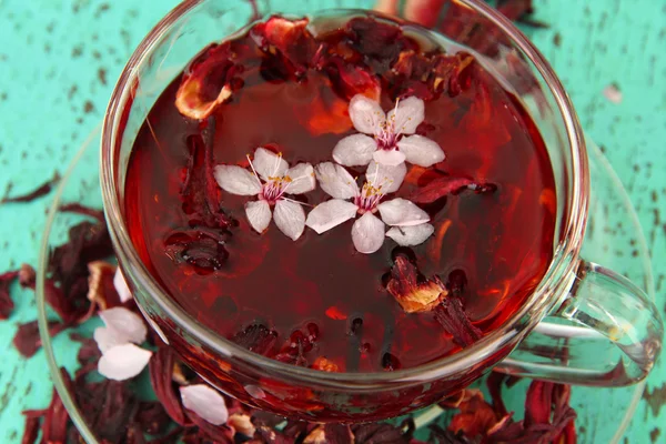 Tisane dans une tasse en verre, sur fond de bois couleur — Photo