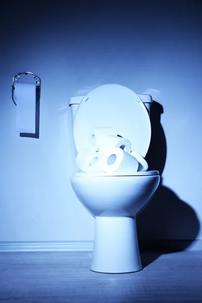 Toilet mangkuk dan kertas toilet di kamar mandi dengan lampu biru — Stok Foto