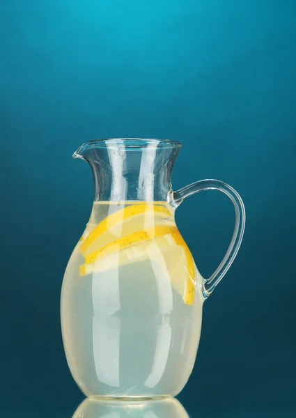 Лимонад в кувшине на голубом фоне — стоковое фото