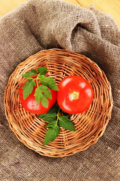 Färska tomater på wicker matta på säckväv bakgrund — Stockfoto