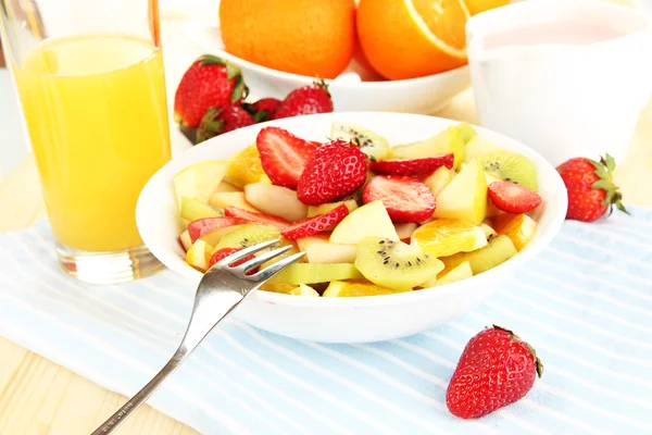 Salada de frutas útil de frutas frescas e bagas em tigela em guardanapo em mesa de madeira close-up — Fotografia de Stock