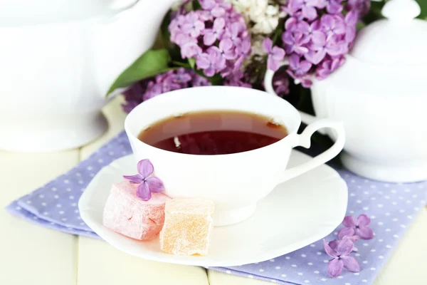 Composición con hermosas flores lila, servicio de té en mesa de madera, primer plano —  Fotos de Stock
