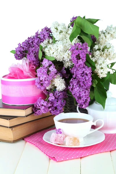 Composition with beautiful lilac flowers, tea service on wooden table on bright background — Stock Photo, Image