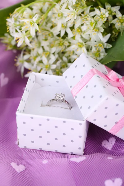 Красивая коробка с обручальным кольцом на фиолетовом фоне — стоковое фото