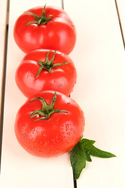 Tomates frescos sobre fundo de madeira branca — Fotografia de Stock