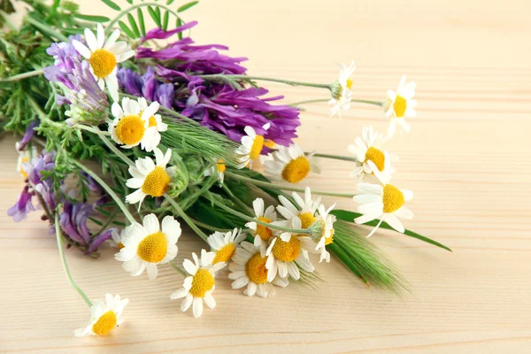 Wild flowers and green spikelets, on wooden background — Stock Photo, Image