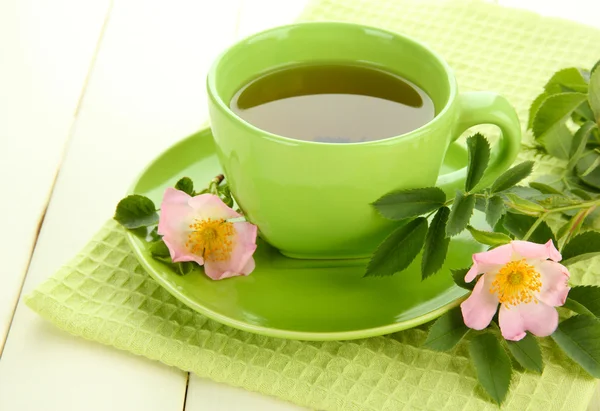 Taza de té de hierbas con flores de rosa de la cadera en mesa de madera blanca —  Fotos de Stock
