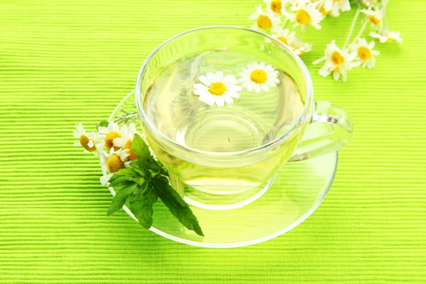 Bylinný čaj s volně camomiles a mátou, na zelený ubrousek — Stock fotografie