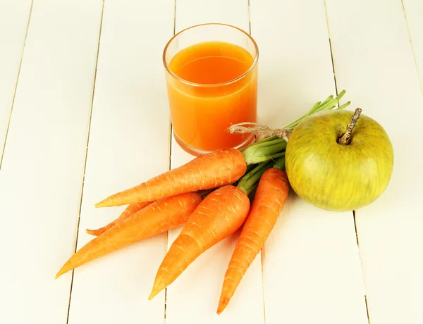 Haufen Karotten und grüner Apfel, Glas Saft, auf farbigem Holzhintergrund — Stockfoto