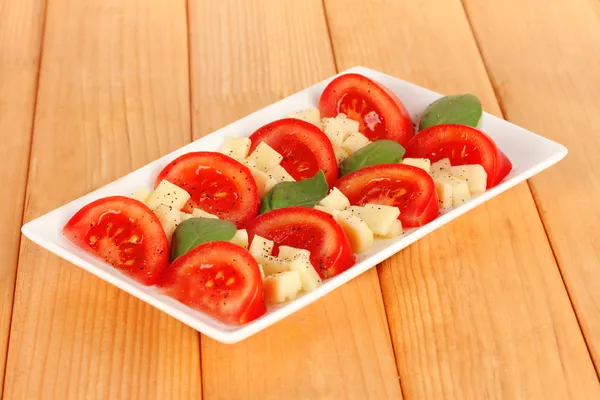 Cheese mozzarella with vegetables in plate on table — Stock Photo, Image