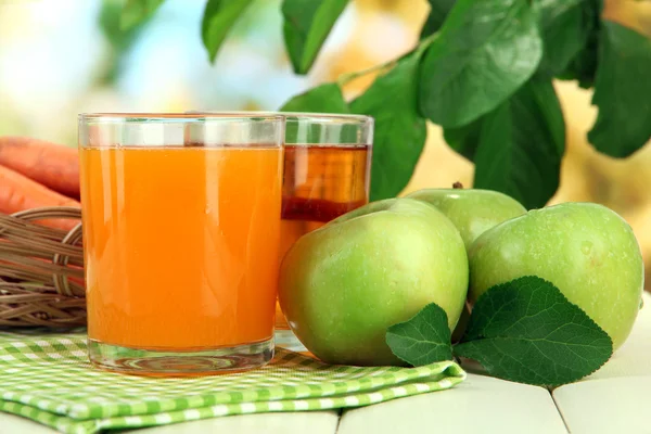 緑色の背景で白の木製のテーブルの上にニンジン、リンゴ ジュースのグラス — ストック写真