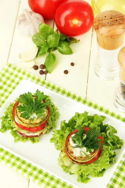 Ízletes sült csontvelő és paradicsom szeletek, saláta levelekkel, fából készült háttér — Stock Fotó