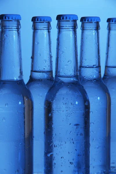 Μπουκάλια νερού σε μπλε φόντο — Φωτογραφία Αρχείου