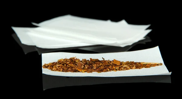 Tobak och cigarettpapper, isolerade på svart — Stockfoto