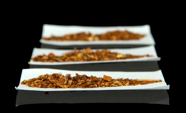 Tabak und Papier, isoliert auf schwarz — Stockfoto