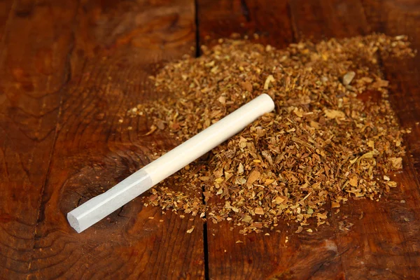 Табак и сигаретные трубки на деревянном фоне — стоковое фото