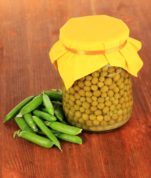 Guisantes verdes sobre fondo de madera — Foto de Stock