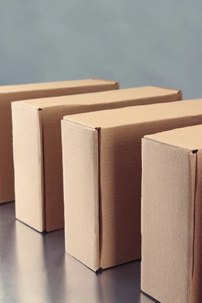 Cardboard boxes on conveyor belt, on grey background — Stock Photo, Image