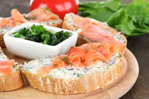 Fish sandwiches on cutting board on wooden table close-up — Stock Photo, Image