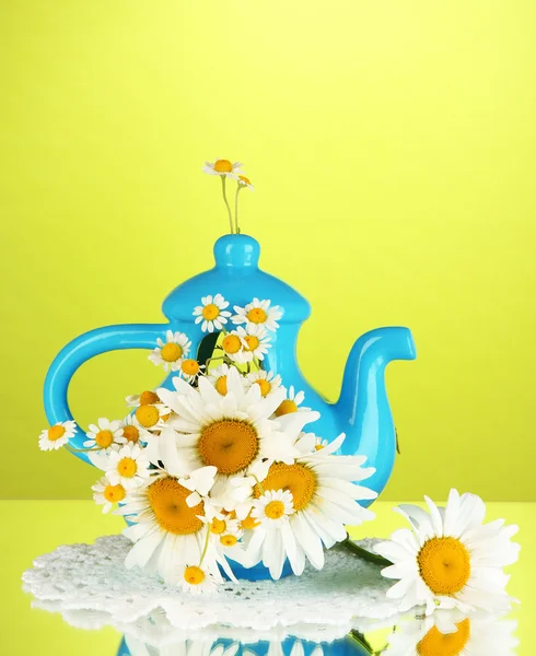 Schöner Strauß Kamillen in Teekanne auf farbigem Hintergrund — Stockfoto